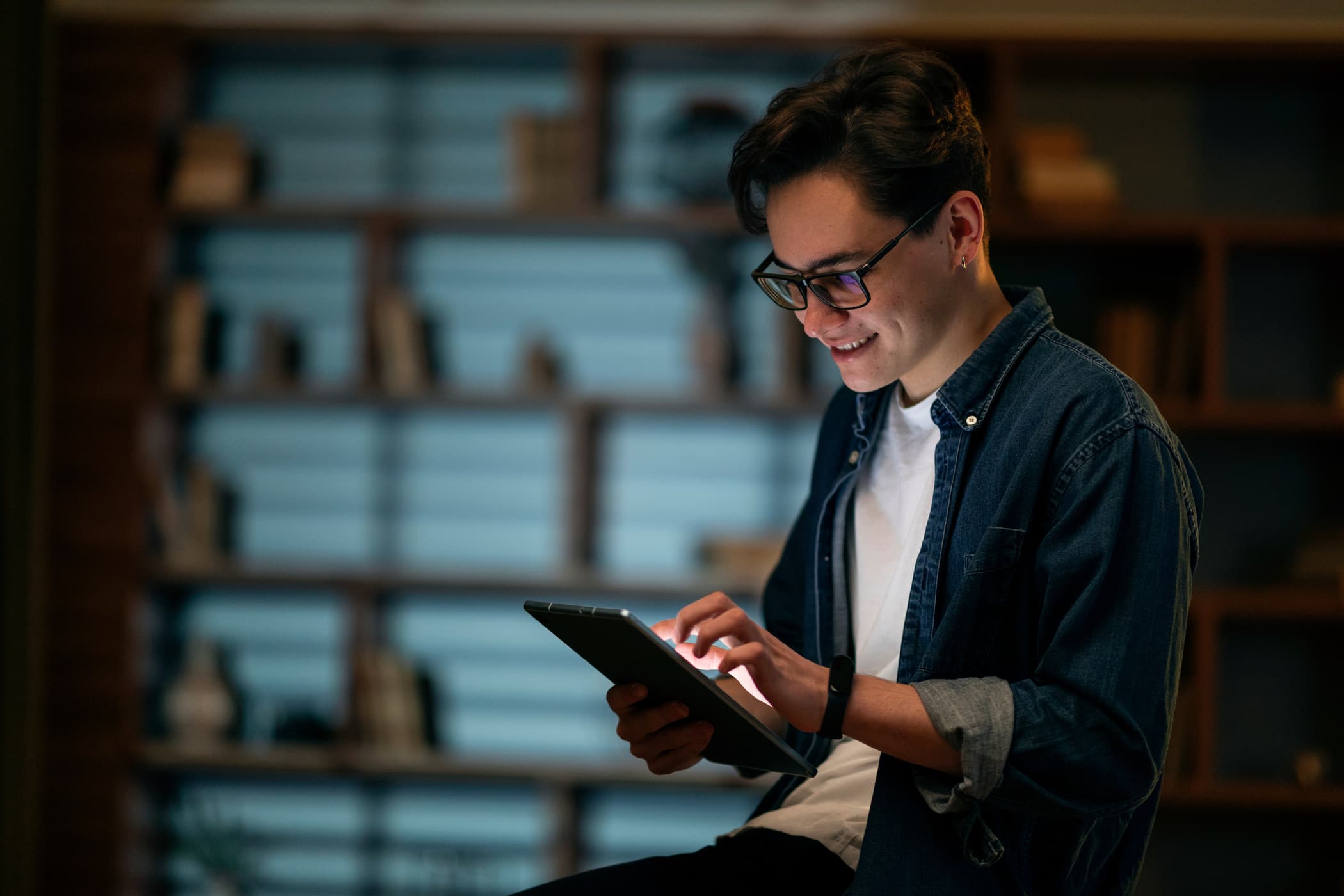 Pessoa sorrindo enquanto usa um tablet em um ambiente de trabalho